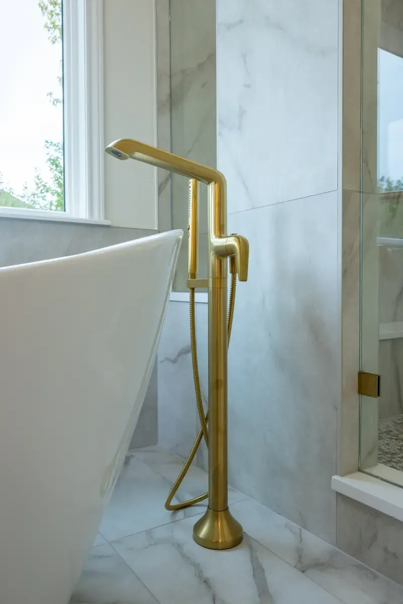 Custom primary bathroom in Erie, Colorado with a freestanding tub and gold fixtures